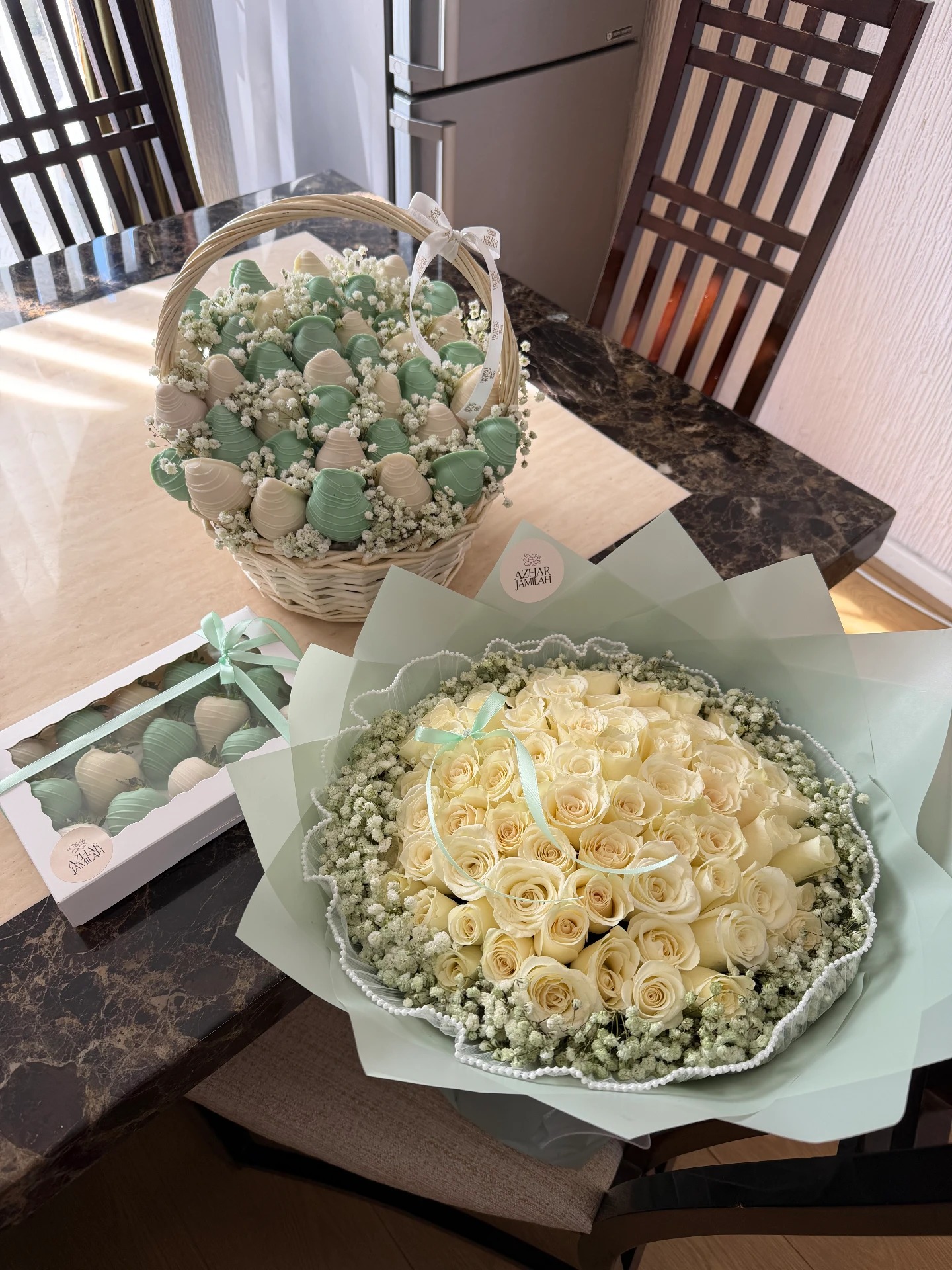 A generous ivory rose bouquet in sage wrapping with baby's breath, paired with a matching basket and box of chocolate-dipped strawberries.