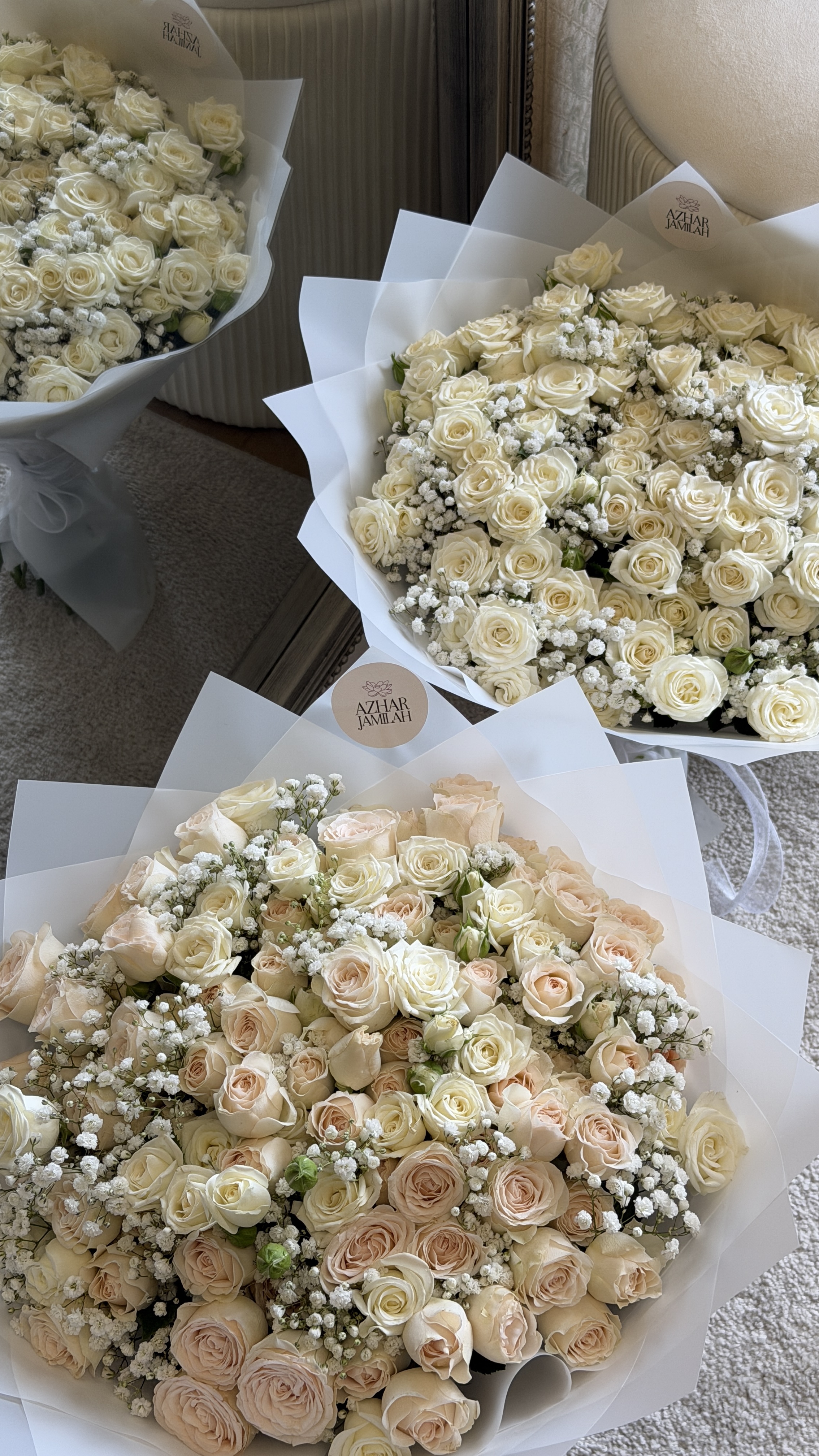 White and champagne roses layered with gypsophila, finished in translucent white wrap.